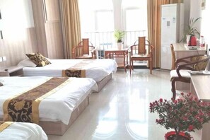 A hotel room with two beds, a dining area, a small kitchen, and a balcony with a potted plant. - Zaozhuang Jingxuan Inn (Zaozhuang)