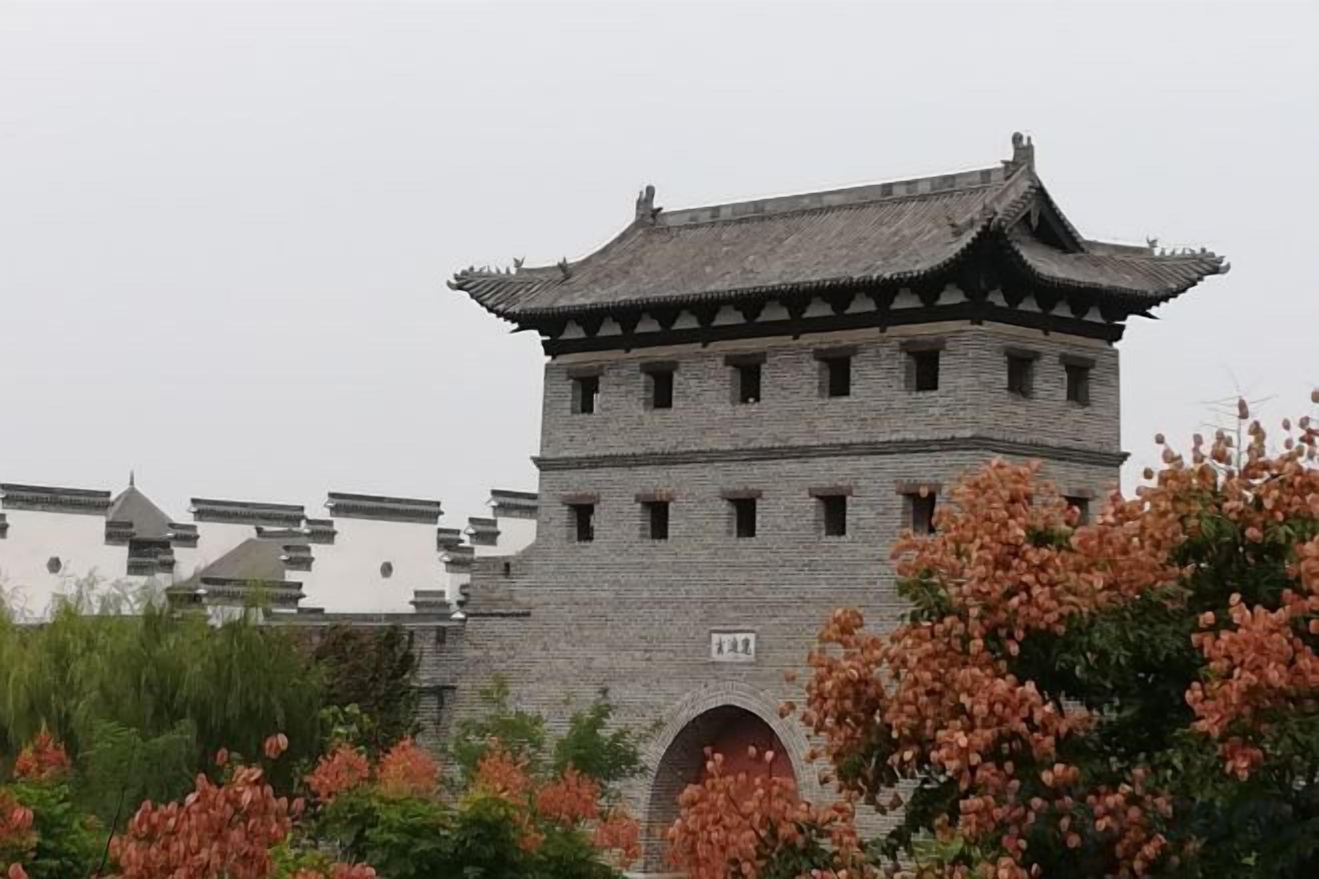 A traditional stone building with a tiled roof and an arched entrance.