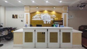 A reception desk with a large elephant mural, a counter, and a motorcycle parked to the left. - Xiwuqi Jindi Hotel (West Ujimqin Banner)