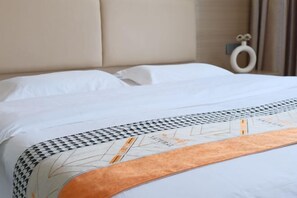 Una cama bien tendida con un edredón estampado y un cabecero.