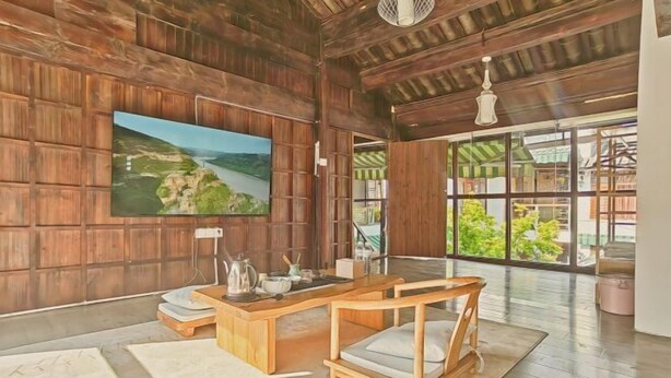 A spacious room with a wooden ceiling, a large window with a view of greenery, a wooden desk, and a painting on the wall. - Shuhe Luye Hotel Lijiang (Lijiang)