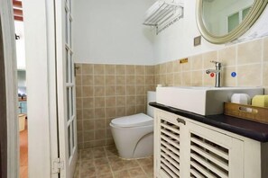 A small bathroom with a toilet, sink, and mirror.