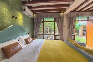 A bedroom with a bed, curtains, and a view of the outdoors.