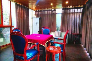 A room with a dining table, chairs, a small round table, and a sofa. - Junchen Business Hotel (Chongqing)