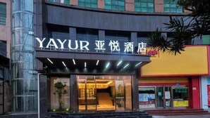 A hotel entrance with a glass facade, a staircase leading to the entrance, and a sign above the door. - Yayue Hotel (Yongxin Central Plaza) (Yongxin)