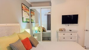A bedroom with a bed, a TV, a nightstand, and a dresser. - Garden Condos Apt 44 - Comfy 1br Apt In Sosua! (Sosúa)