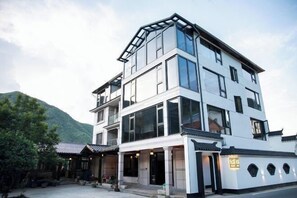 Een modern meerlaags gebouw met grote ramen en een entree in traditionele stijl.