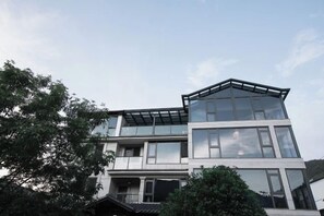 A modern two-story building with large windows and a flat roof.