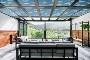 A modern interior with a large window, a sofa, and a wooden wall. - Anji Dongsha Lake Farm Stay (Anji)