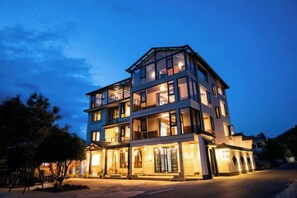 A multi-story hotel with a prominent entrance and a balcony on the upper floor.