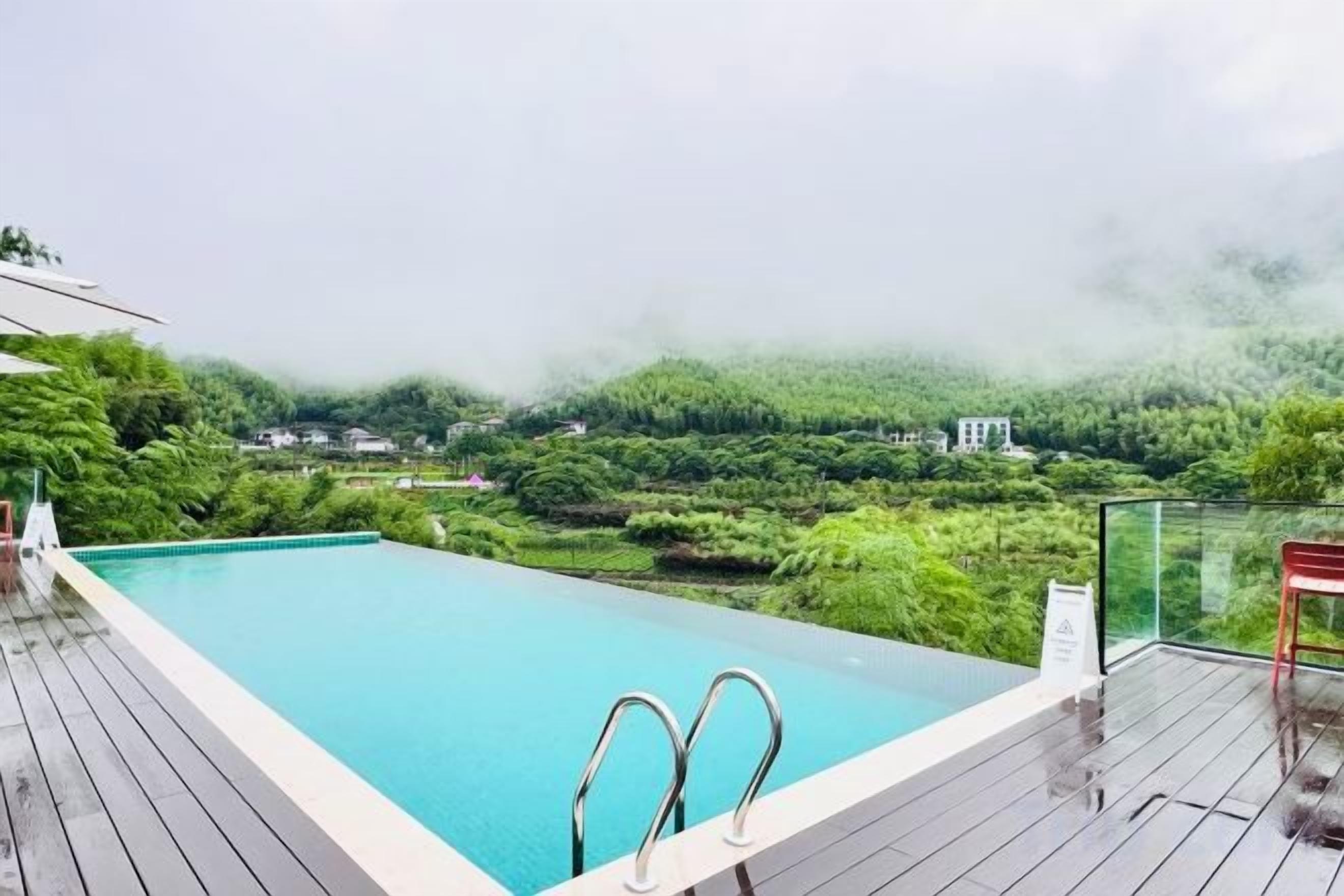 Une piscine offrant une vue sur un paysage boisé.