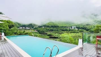 Une piscine offrant une vue sur un paysage boisé.