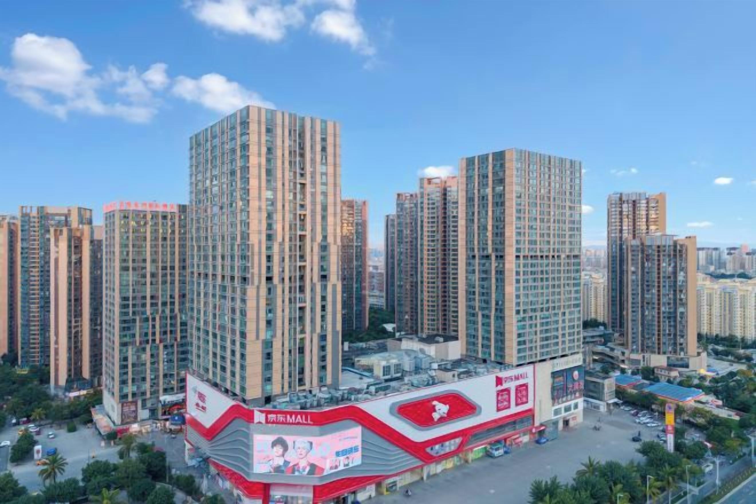 Ein Hochhaus mit einer auffälligen, rot-weißen Beschilderung, umgeben von weiteren hohen Wohnhäusern.