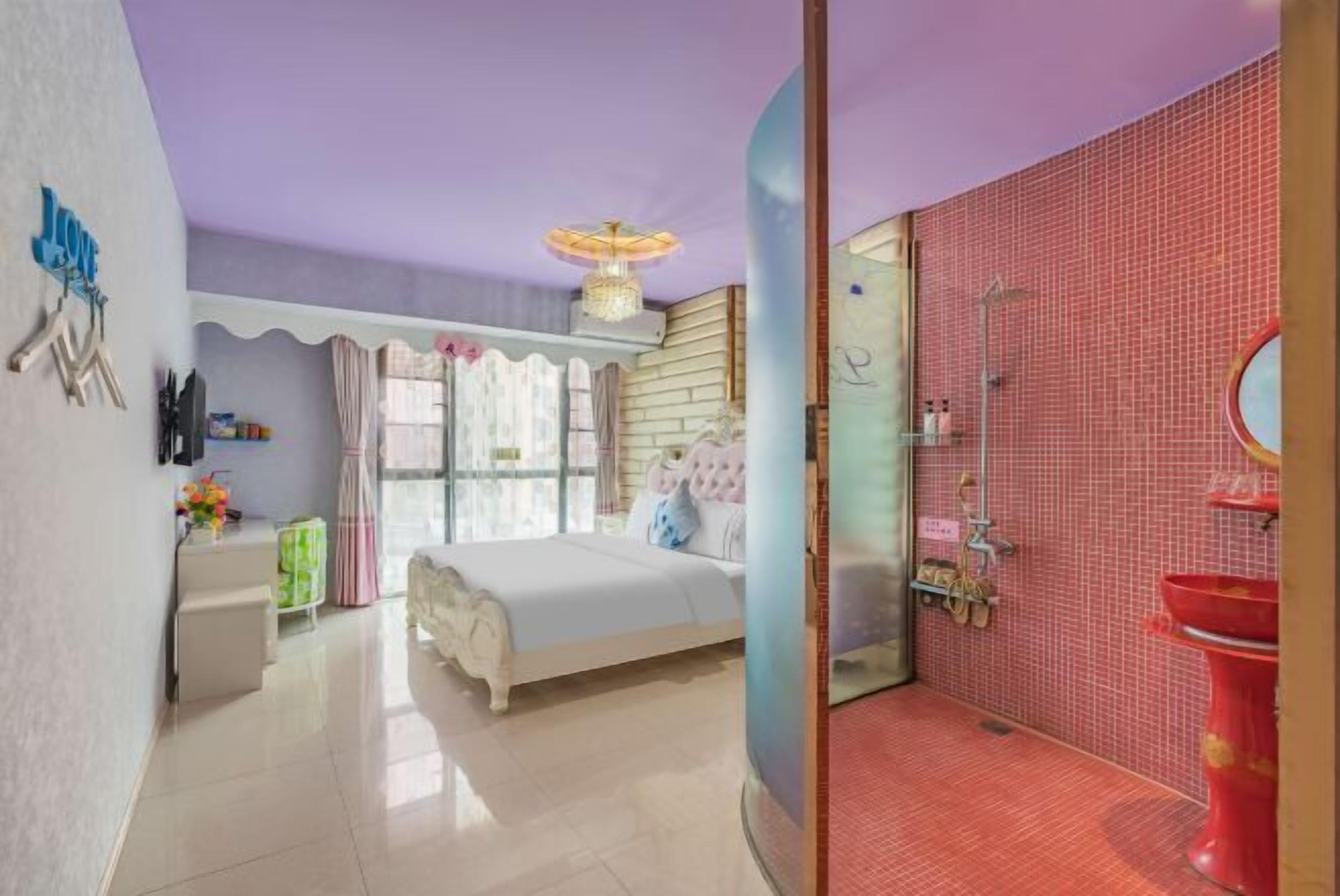A bedroom with a bed, bedside table, and a window with curtains.