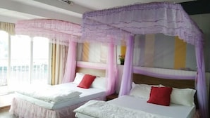 A room with two beds, each with a canopy and pillows.