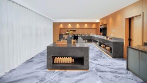 A modern kitchen with a marble countertop, built-in appliances, and a central island.