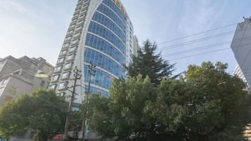 A tall, modern building with a curved facade and multiple windows.