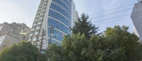 A tall, modern building with a curved facade and multiple windows.