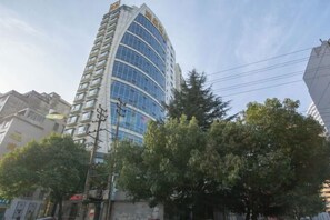 Un edificio alto y moderno con fachada curva y numerosas ventanas.