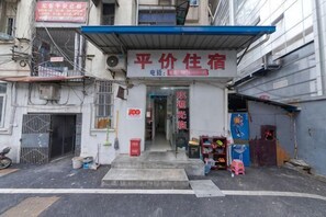 A building with a signboard for a hotel or lodging establishment. - Optics Valley Affordable Apartment (Wuhan)