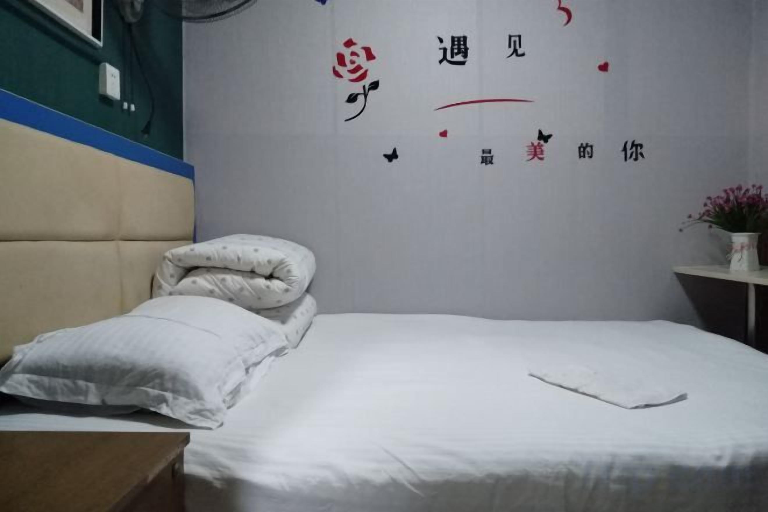 Ein Hotelzimmer mit einem Bett, Kissen, einem Nachttisch und einer Wand mit dekorativen Stickern.