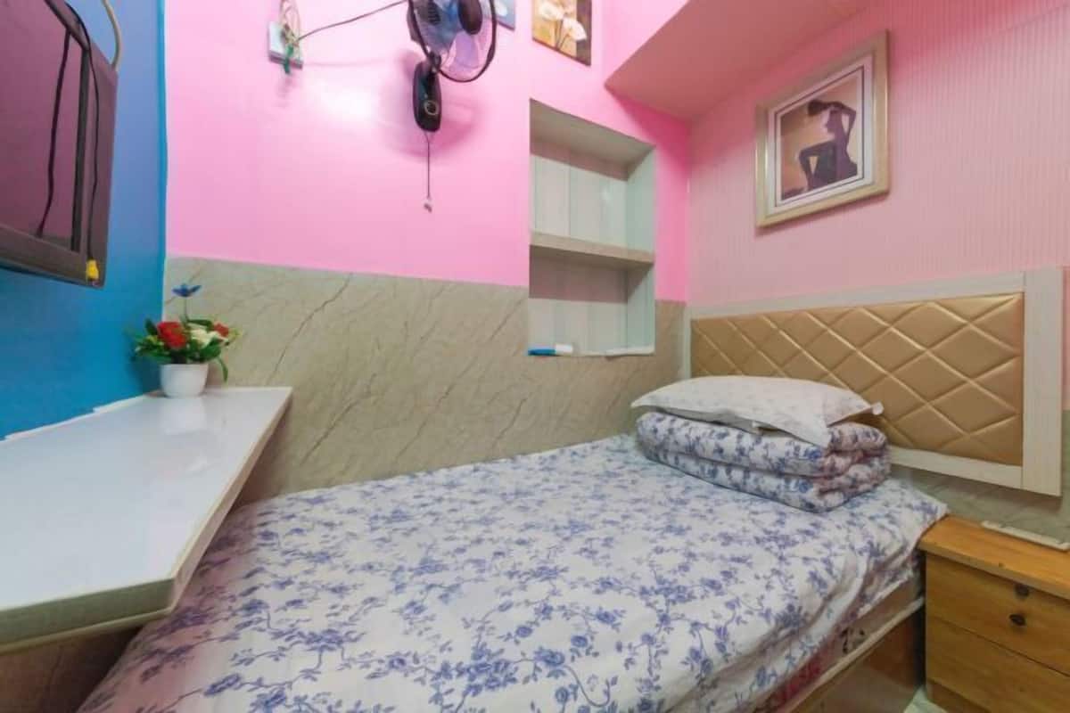 Ein Schlafzimmer mit Bett, Nachttisch und kleinem Nachtschränkchen.