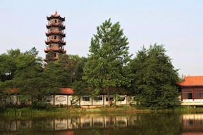 A pagoda-style tower, a pond, and a traditional building with a red roof. - Optics Valley Affordable Apartment (Wuhan)