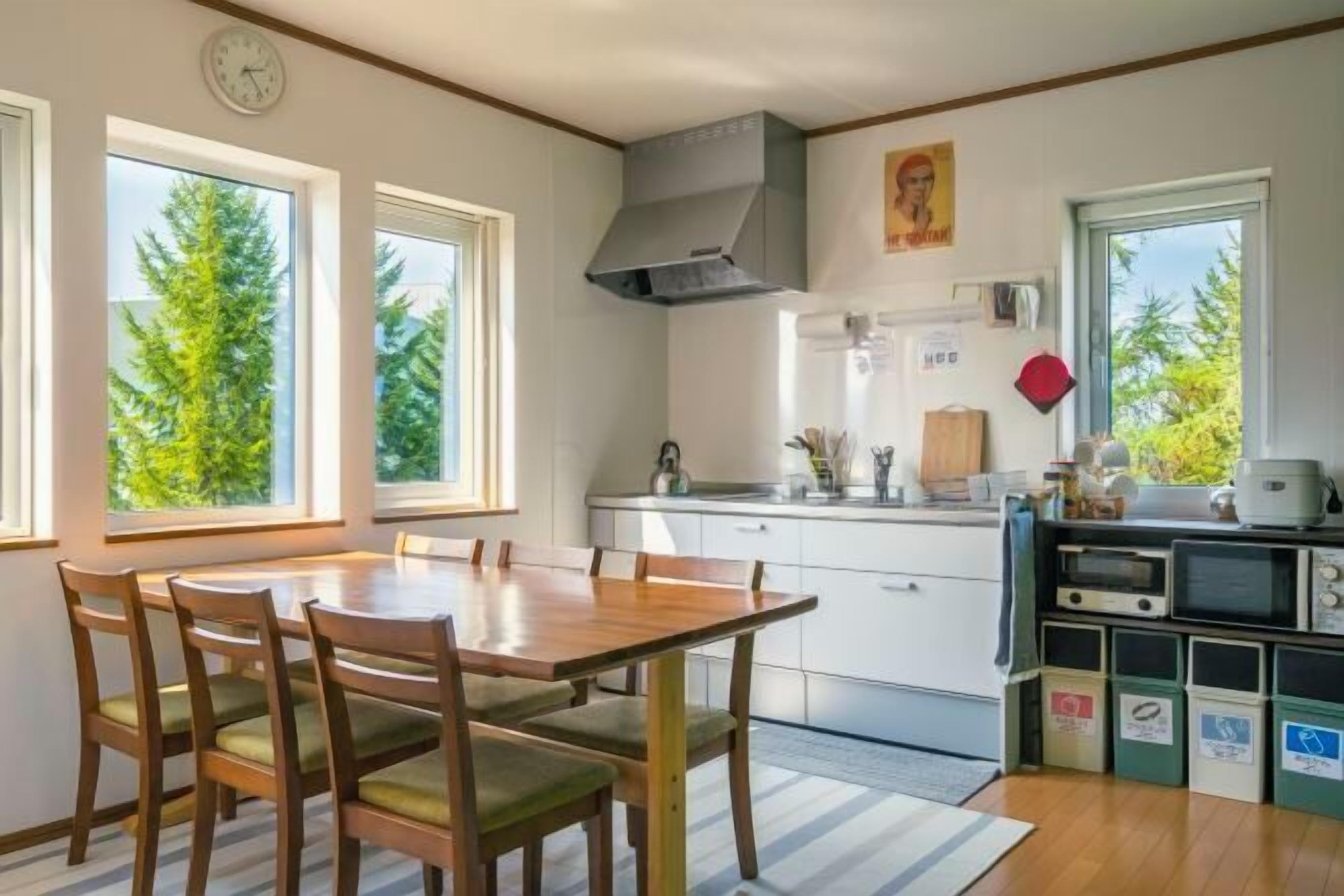 A kitchen with a dining table, chairs, a stove, and a microwave.