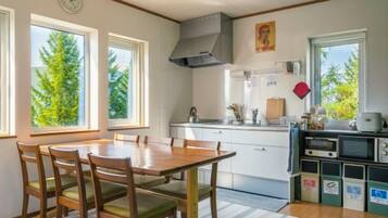 A kitchen with a dining table, chairs, a stove, and a microwave.
