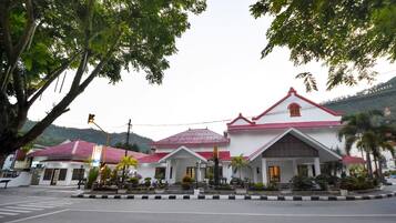 A white building with a red roof and multiple entrances.