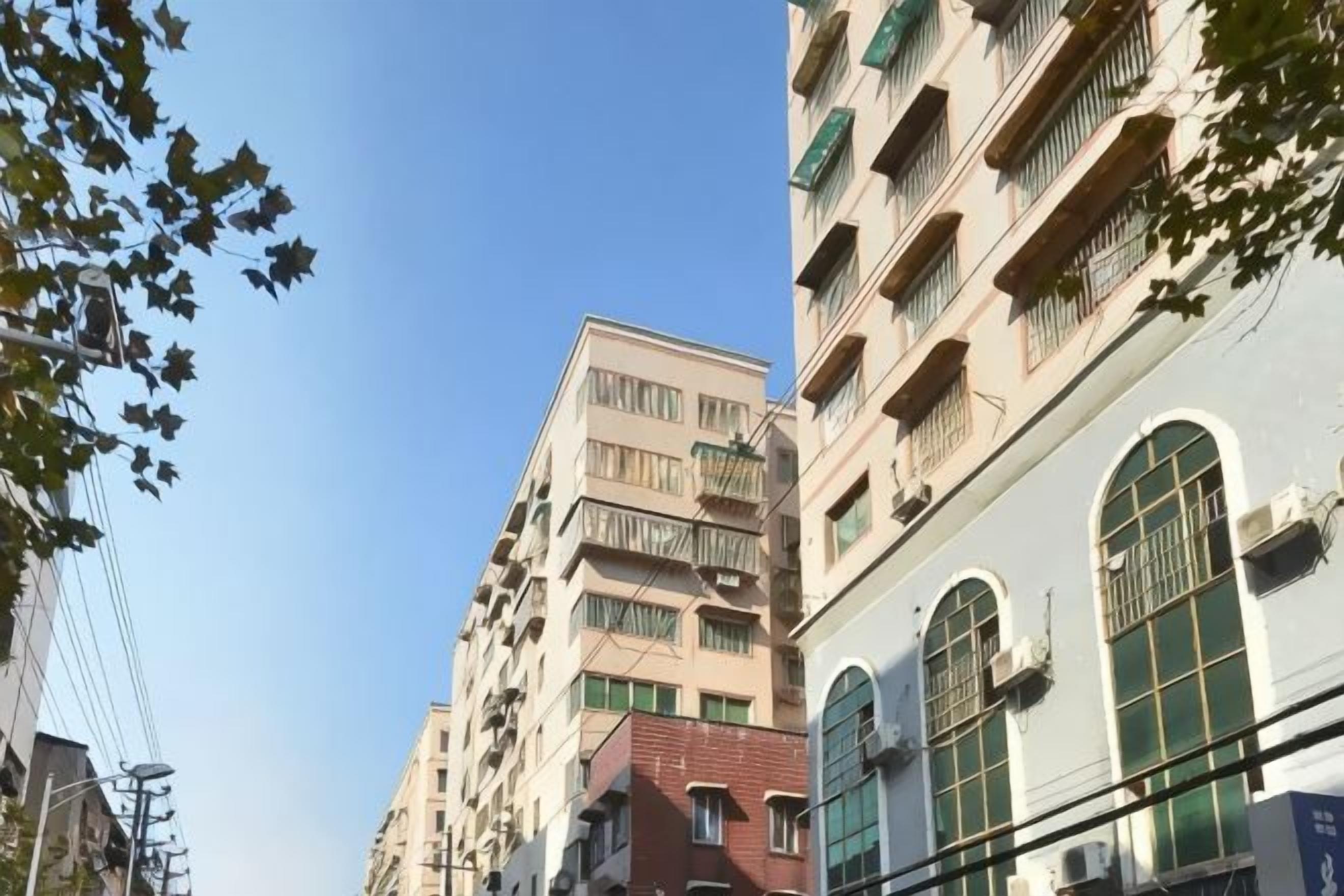 A multi-story building with balconies and large windows.