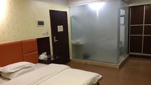 A hotel room with a bed, a wardrobe, a door, and a sliding glass door. - Jiangnan Hotel (Jiangmen)