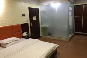 A hotel room with a bed, a wardrobe, a door, and a sliding glass door. - Jiangnan Hotel (Jiangmen)