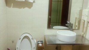 Un bagno con il water, lavandino, specchio e porta asciugamani.
