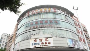 Un edificio a più piani con diversi cartelli pubblicitari.