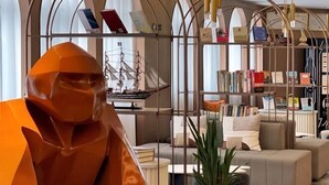 Un salon moderne agrémenté d’une sculpture géométrique, d’une bibliothèque et d’un coin salon confortable.