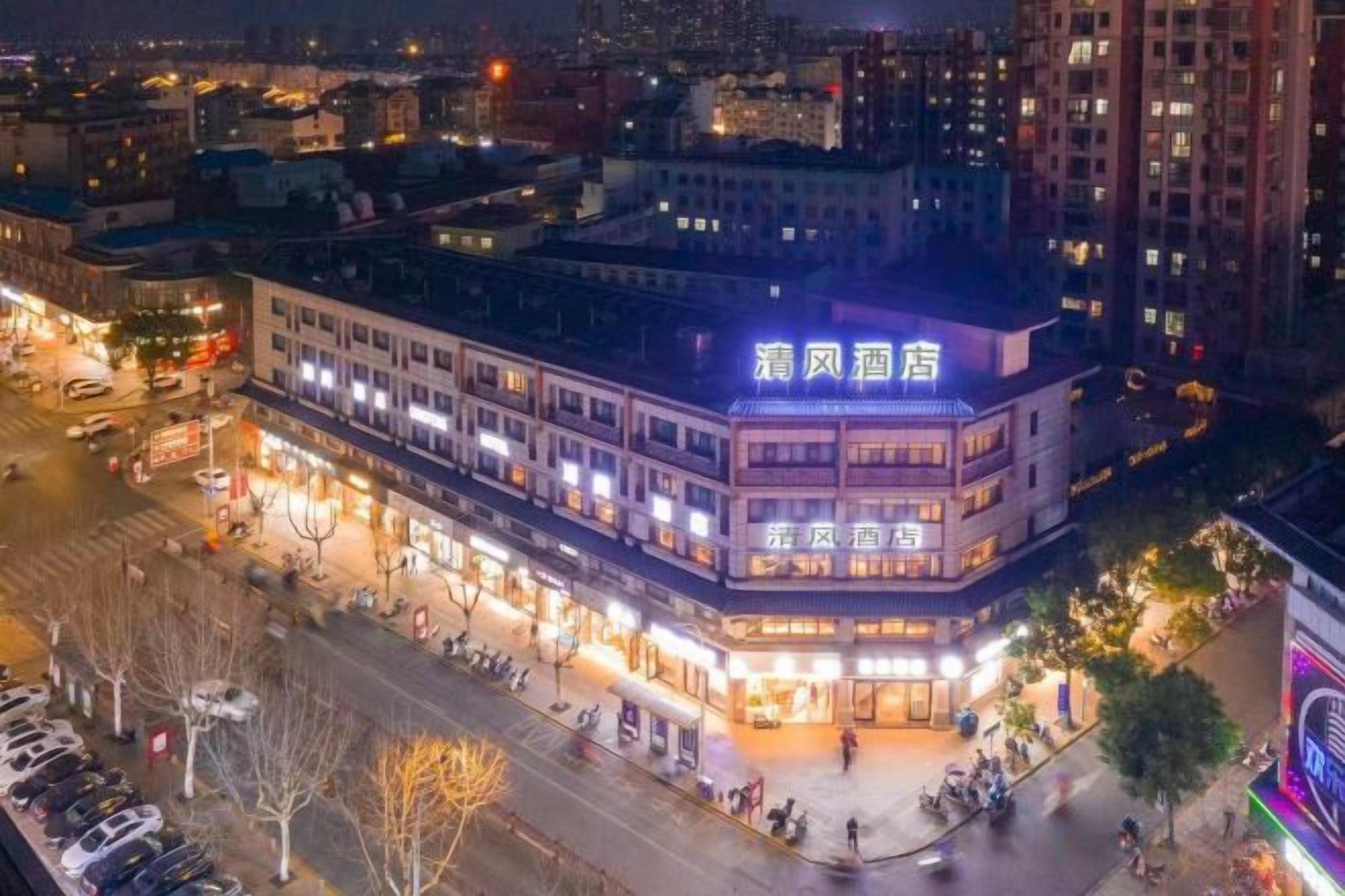 A multi-story building with illuminated signage, a central courtyard, and surrounding streets.