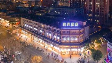 A multi-story building with illuminated signage, a central courtyard, and surrounding streets.