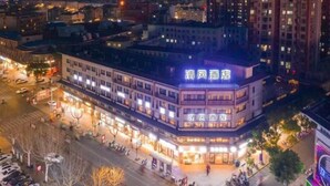 Un hôtel avec une enseigne bien visible, de nombreux étages et une entrée au niveau de la rue.