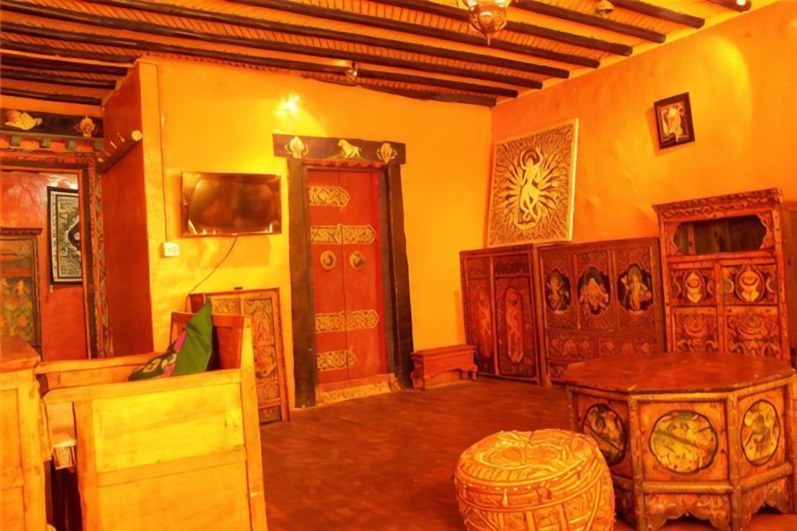 Une pièce avec un plafond en bois, une grande porte richement décorée et un meuble traditionnel.