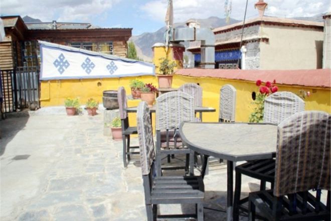 Un patio al aire libre con mobiliario de mimbre y plantas en macetas.