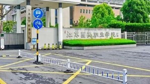A hospital entrance with a signboard, a bicycle symbol, and a white fence. - Yancheng Xinyue Theme Hotel (Jiangsu Vocational College of Medicine Kangleyuan Branch) (Yancheng)