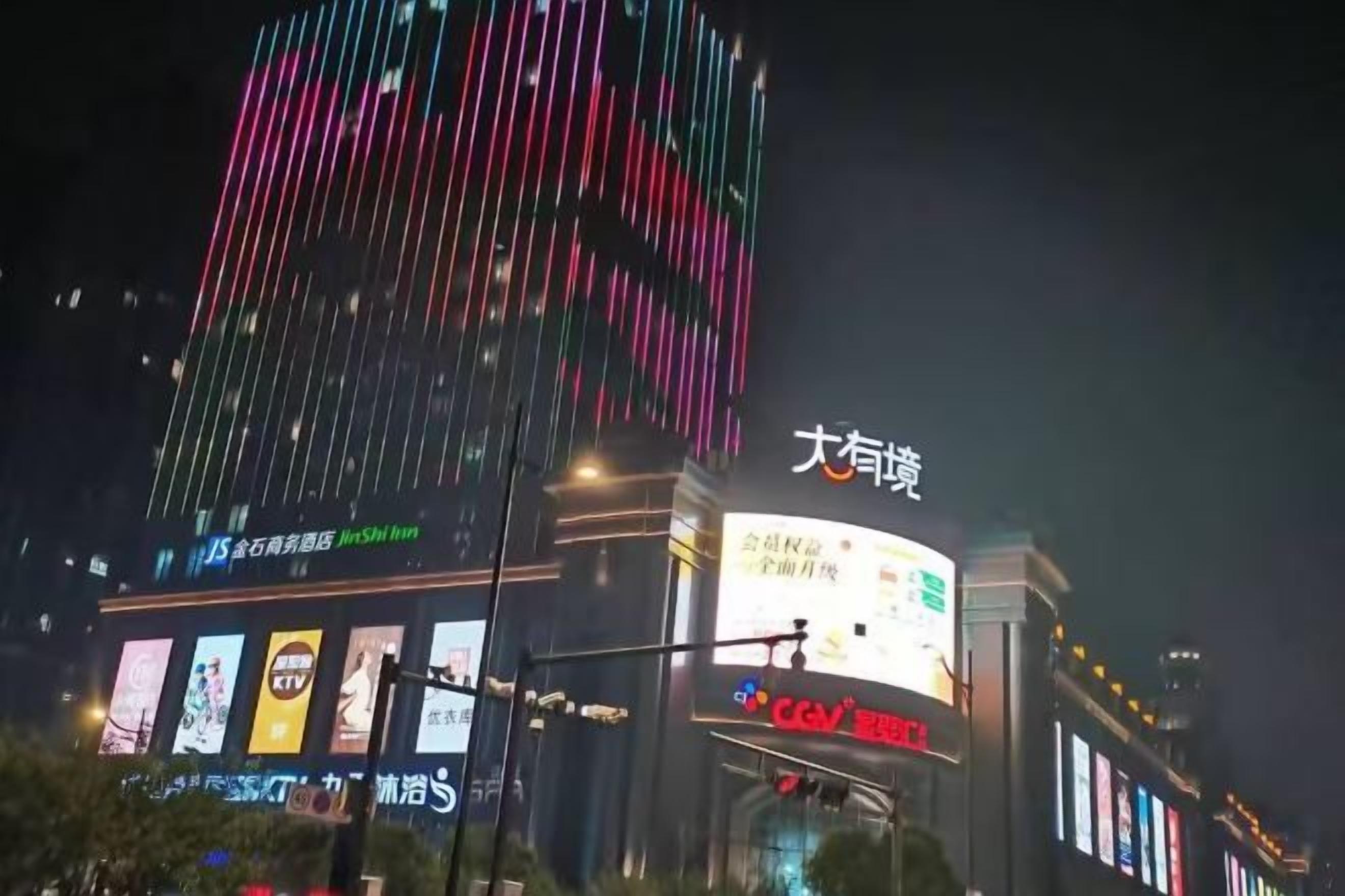 Un edificio con señalización iluminada y una pantalla digital.
