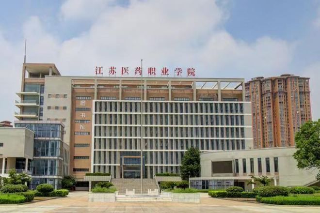 Un edificio de varios pisos con una entrada destacada y un cielo despejado.