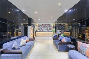A hotel lobby with sofas, a reception desk, and a view of the street. - PRETTY BANK HOTEL (Taiyuan)