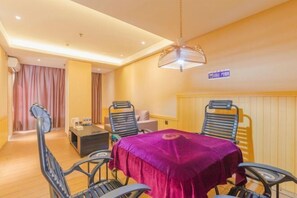 A hotel room with a dining table, chairs, a small sofa, a coffee table, and a ceiling fan. - PRETTY BANK HOTEL (Taiyuan)