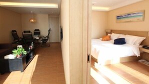 A hotel room with a bed, a desk, a chair, a TV, and a plant. - PRETTY BANK HOTEL (Taiyuan)