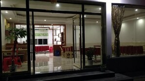 Un hall de hotel con mostrador de recepción, zona de estar y un ventanal grande.