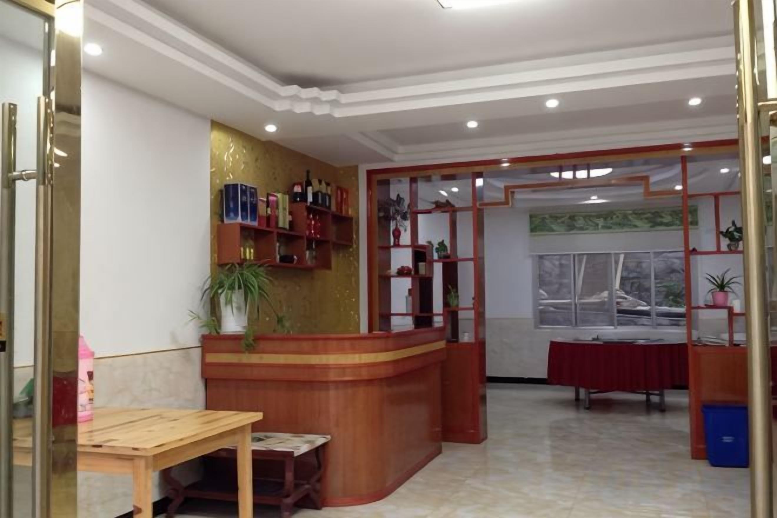 A reception area with a wooden counter, a table, and a window with a view.