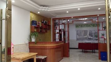 A reception area with a wooden counter, a table, and a window with a view.